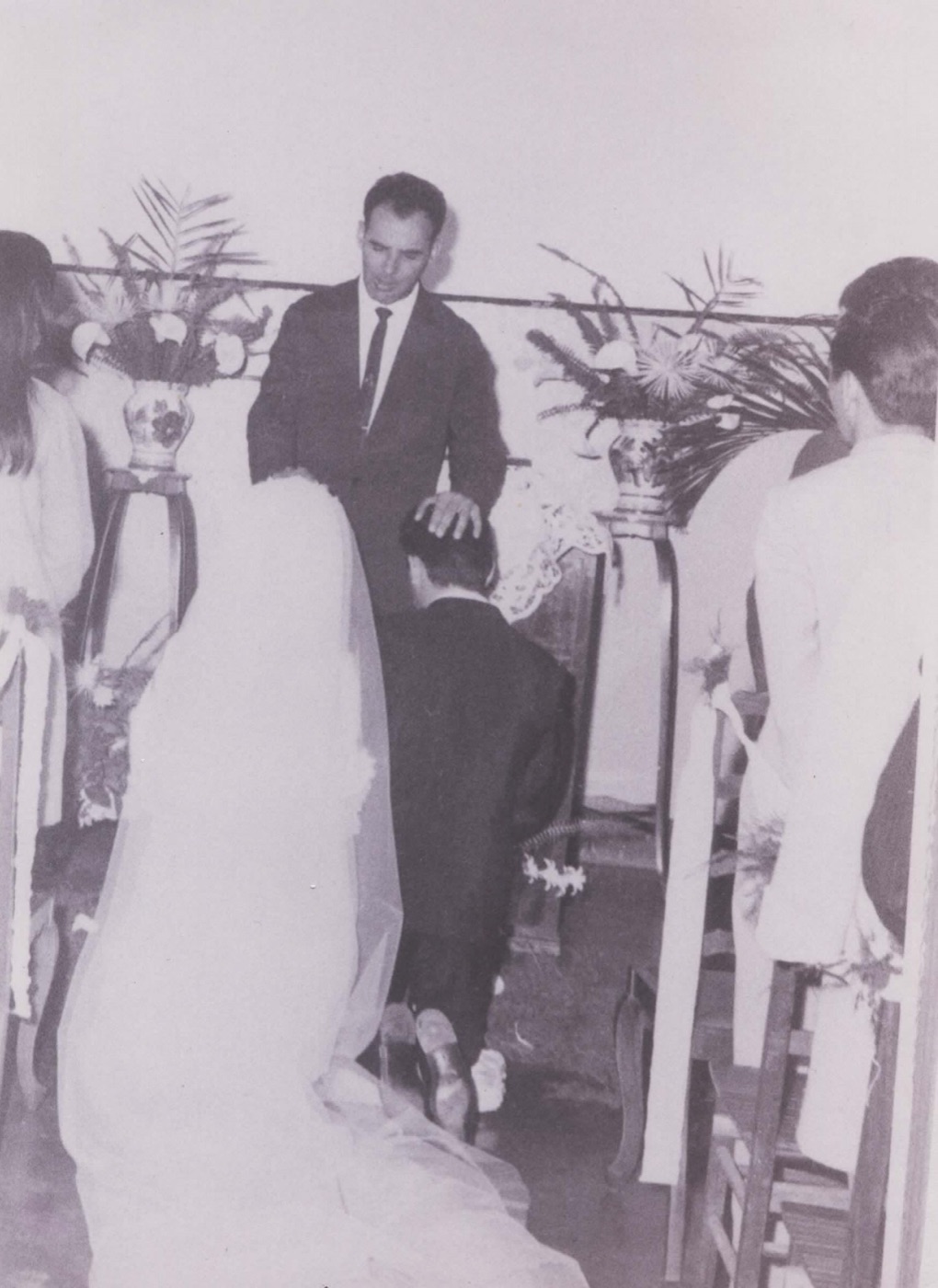 Antenor celebrando um casamento e orando pelos noivos ajoelhados, em foto antiga em preto e branco.