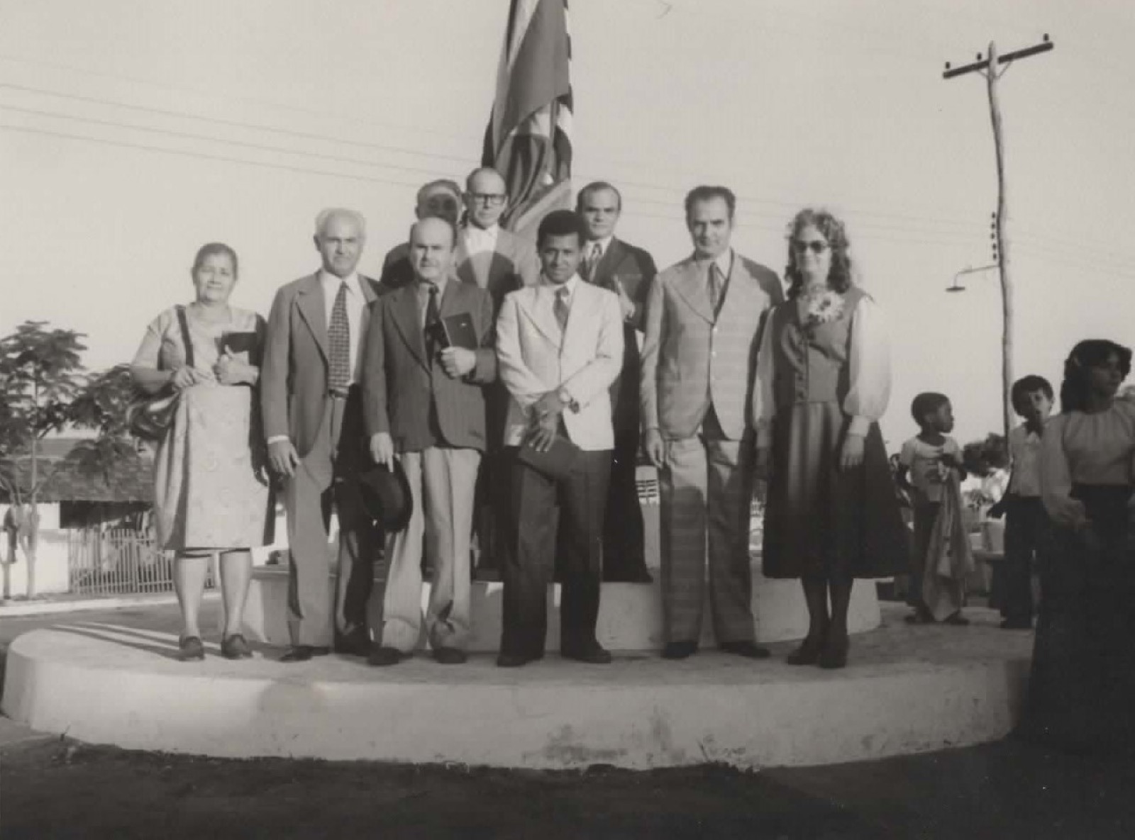 Grupo de líderes reunidos diante de um mastro com a bandeira de São Paulo, em foto antiga em preto e branco.